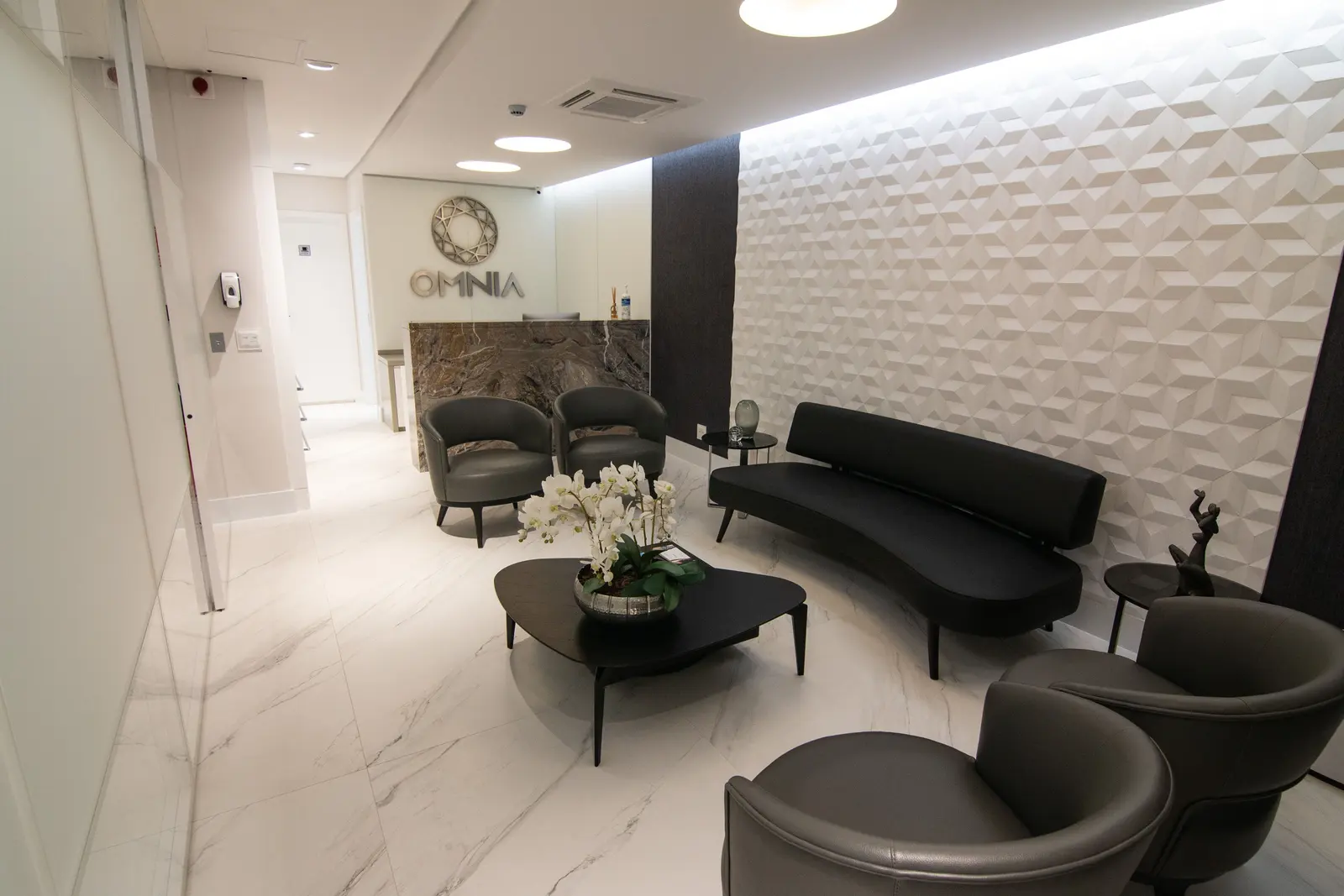 Recepção da Omnia, com o balcão, o letreiro e a sala de espera