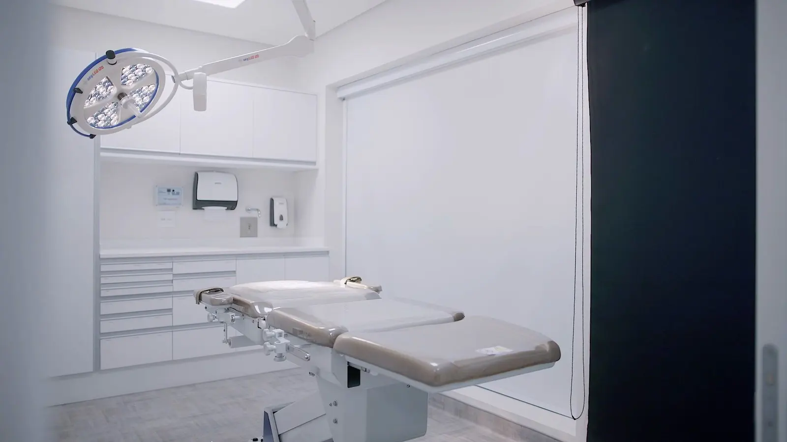 Sala de procedimentos com maca e foco cirúrgico